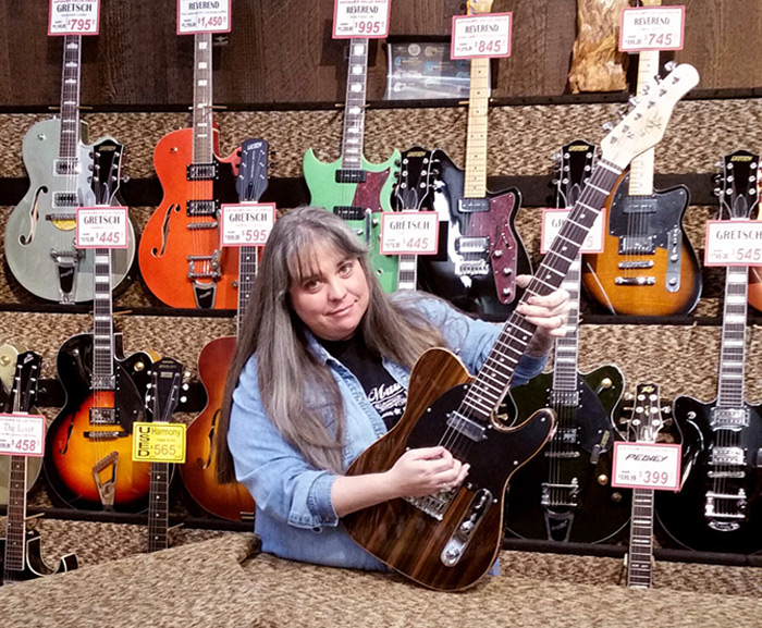 Amy at Arthur's Music Store with a Michael Kelly 1950s Ebony electric guitar