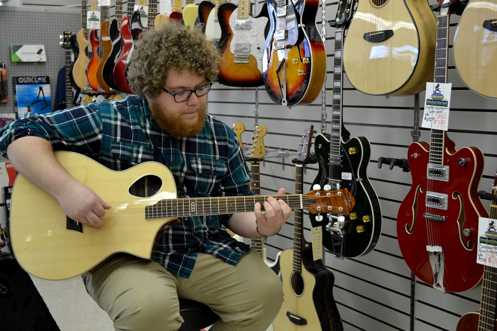 Bob from King Music Inc holding a Michael Kelly Triad Port acoustic guitar