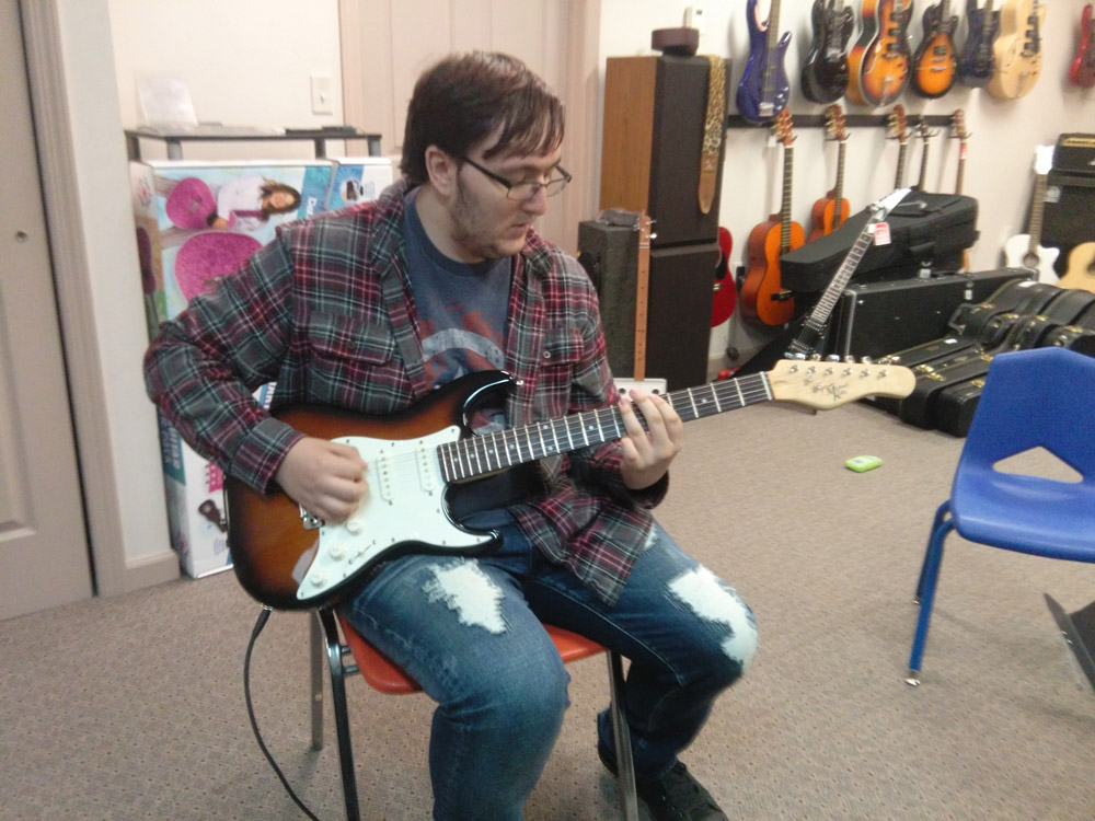 Student learning to play guitar at Robert Putt Studios on a Michael Kelly 1960s electric guitar.
